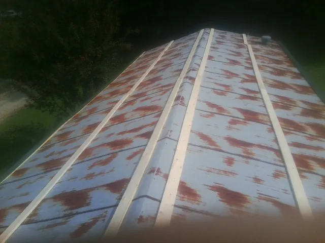 Rusted metal roof panels with new wood purlins before replacement — Storm Damage Roof Repair in Antigo by Roofing Brothers