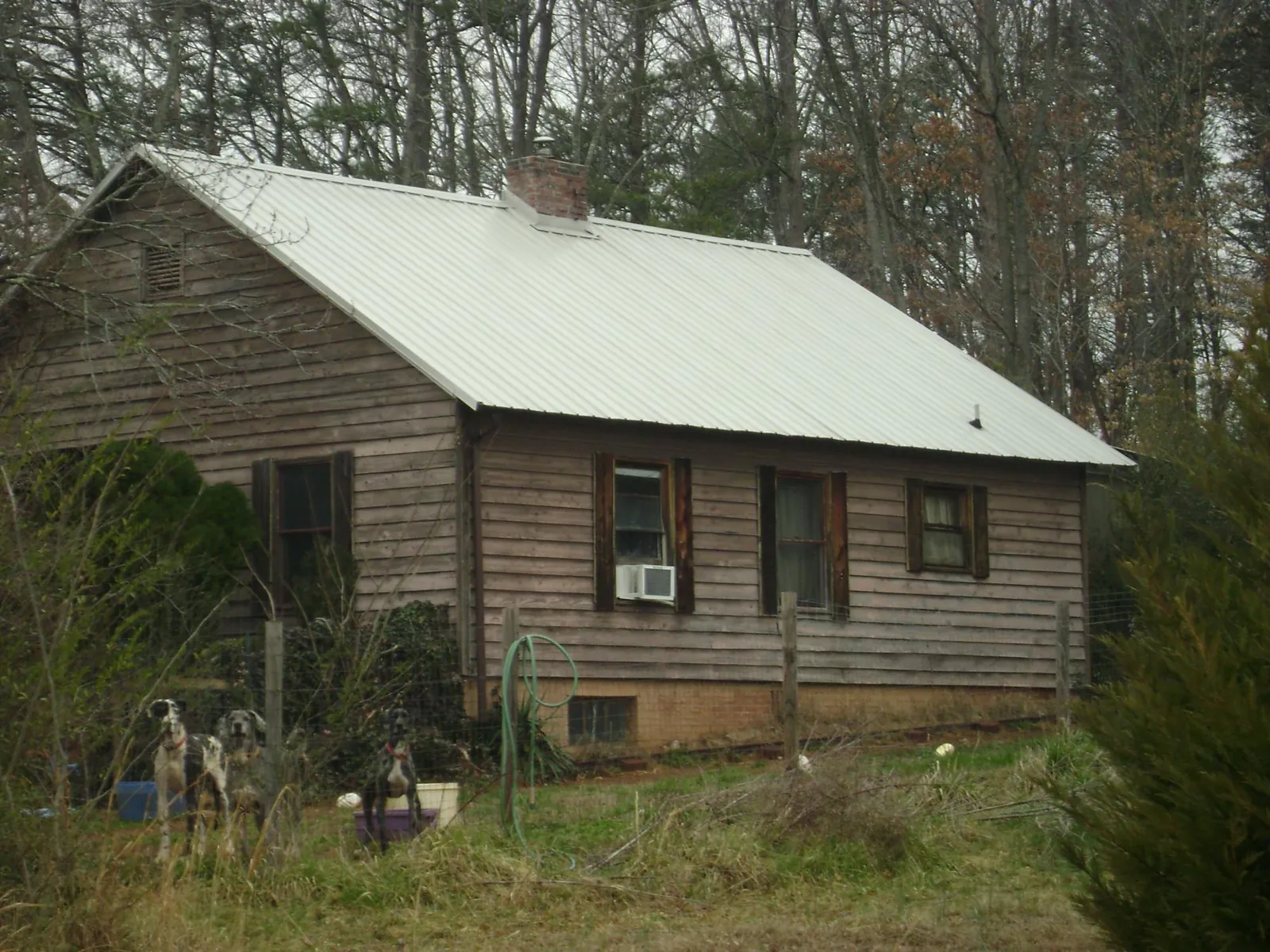 White metal roof on an old wood sided farmhouse, from a Metal Roof Installation job in Antigo